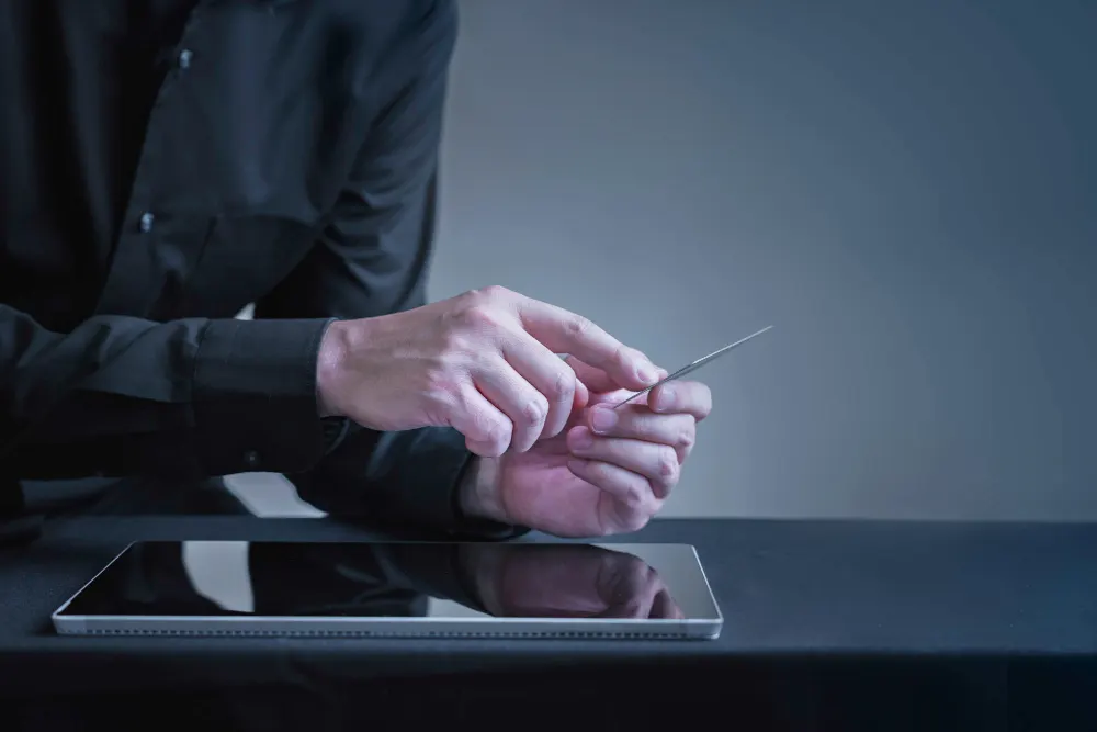 Person holding a payment card above a tablet